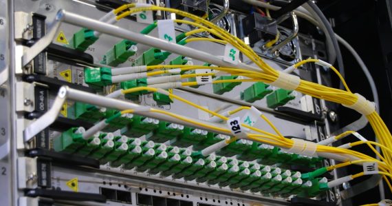 Fiber optic cables connected to a network switch in a server rack, illustrating thin clients and fast networks