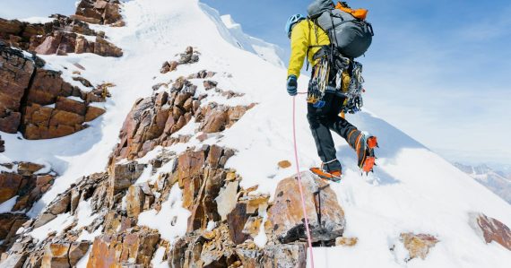 Climber ascending a snow-covered mountain, illustrating the top challenges to cloud computing