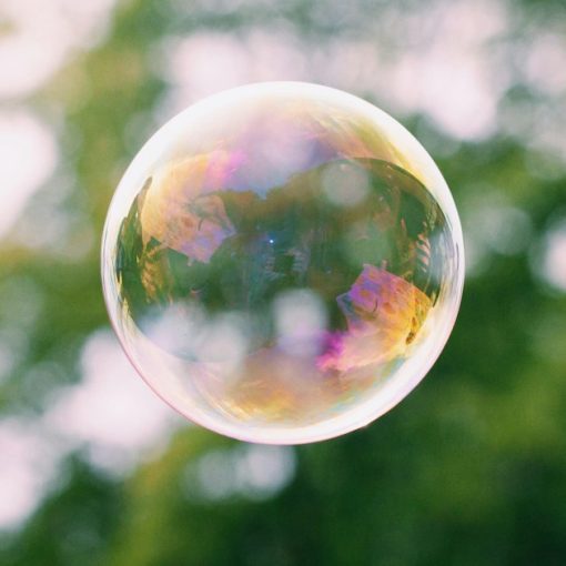 A close up of a soap bubble with trees in the background, illustrating unified communications spending
