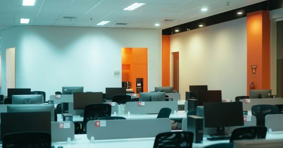 A room filled with lots of desks and computers, illustrating VDI for business services deployment