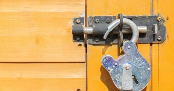 Wooden door secured with a padlock, illustrating securing a virtual environment