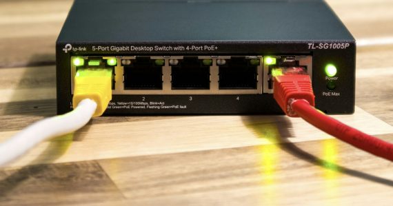A network switch with ethernet cables connected, illustrating virtual networking's impact on the industry