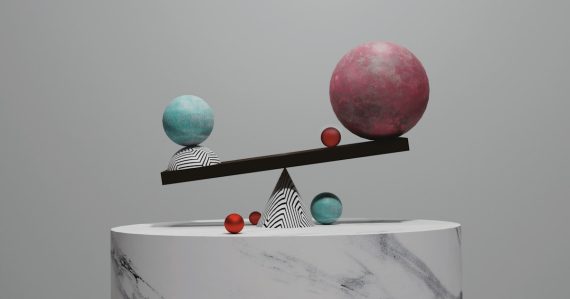 Balance scale with spheres on a marble pedestal, illustrating virtualization as the big equalizer