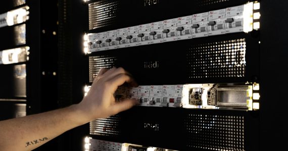 A hand adjusting components in a glowing server rack, illustrating the future of virtualization management