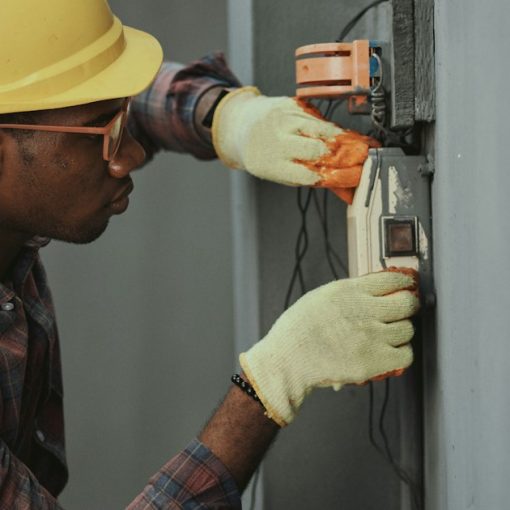 Electrician installing wiring with yellow hardhat, illustrating troubleshooting virtualized cloud environments