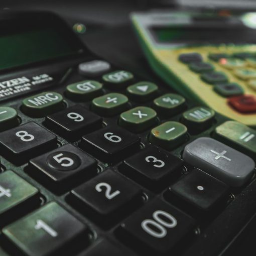 A calculator sitting on top of a table next to another calculator, illustrating VoIP cost benefits