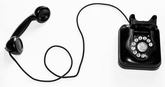 Photo of black rotary phone against white background, illustrating rising VoIP hacking