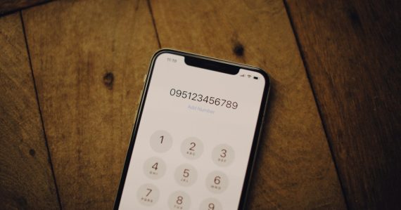 A cell phone sitting on top of a wooden table, illustrating VoIP security for small businesses