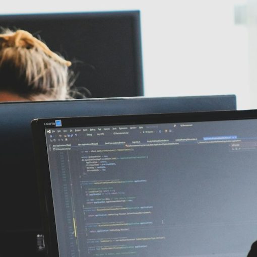 Two developers working on code at monitors in a bright office, illustrating service virtualization