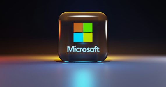 A glossy glass cube with the Microsoft logo on a dark surface, illustrating Microsoft's confusingly named Live products