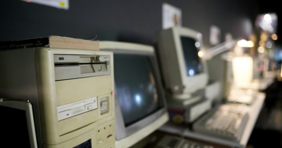 A row of old computers sitting on top of a desk, illustrating Windows ThinPC