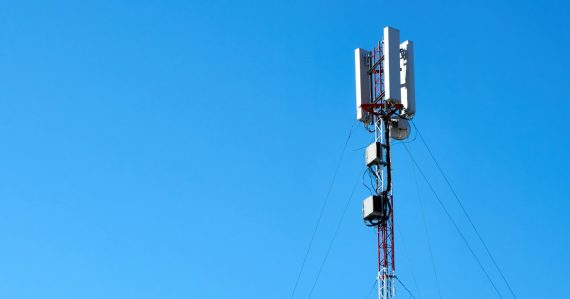 Cell tower with wireless antennas against a blue sky, illustrating network functions virtualization