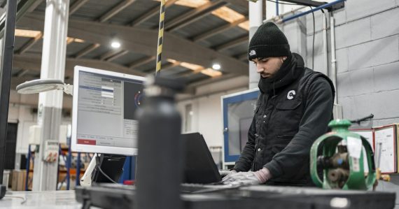 Man works on a computer in a manufacturing setting, illustrating AutoCAD on VDI with XenDesktop
